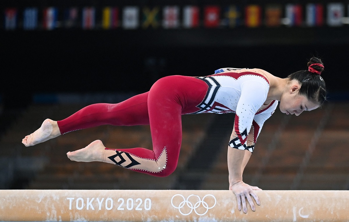 Gimnasta Kim Bui în timp ce execută un exercițiu la bârnă și stă sprijinită doar în mâini în cadrul Jocurilor Olimpice de la Tokyo 2021
