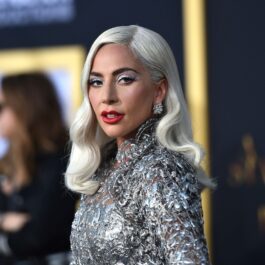 Lady Gaga într-o rochie cu paiete argintie în timp ce se află pe covorul roșu la premiera filmului A Star Is Born din 2018