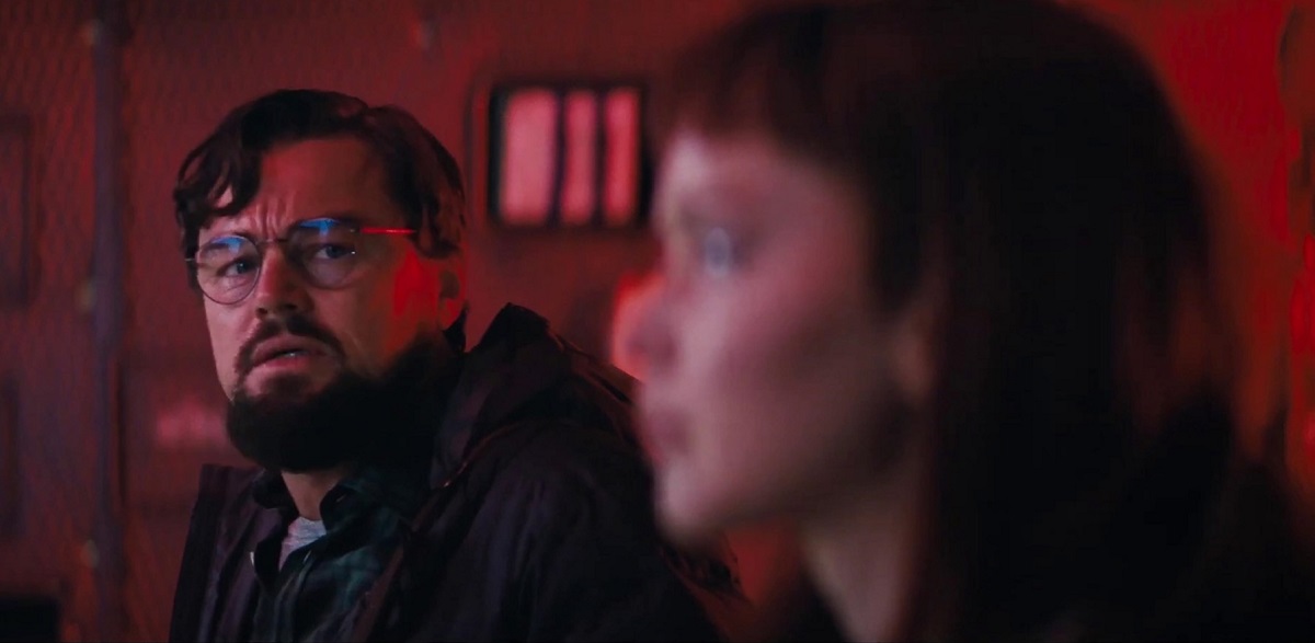 Leonardo DiCaprio alături de partenera sa de scenă într-o încăpere roșie în pelicula Don't Look Up