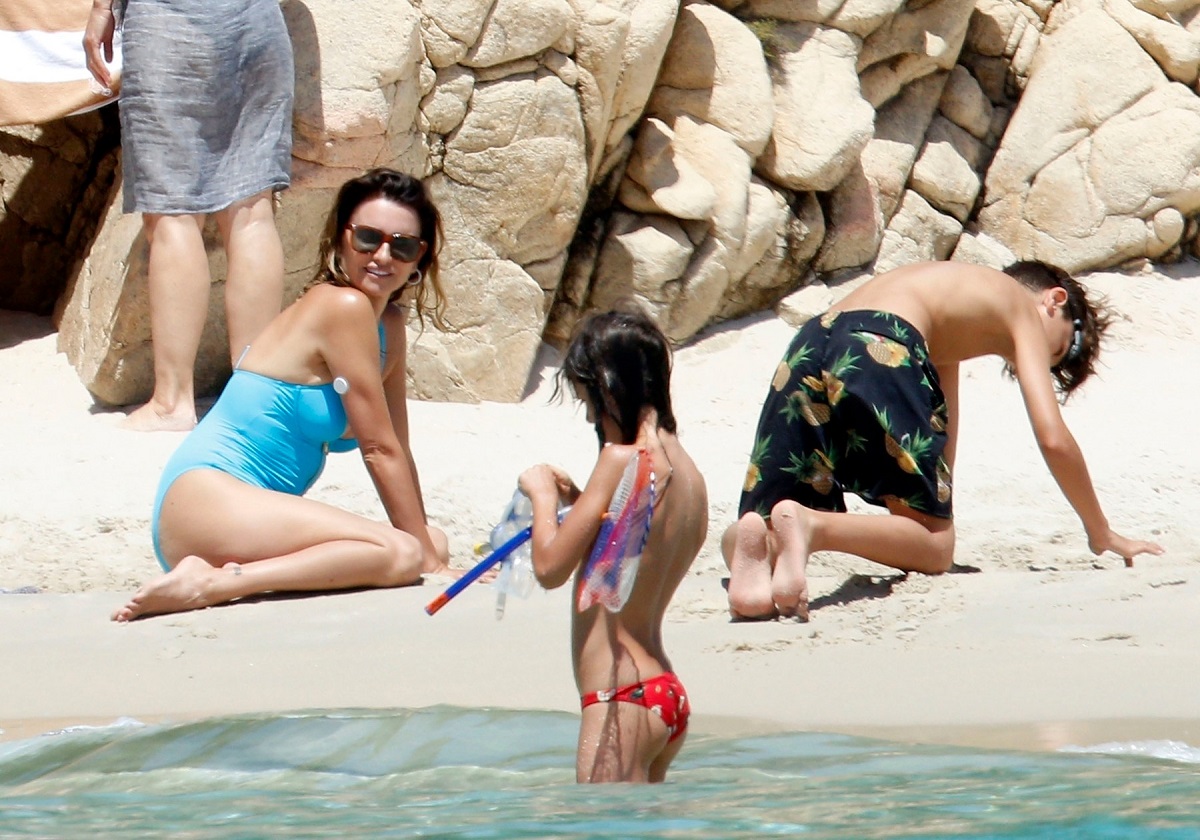 Penelope Cruz pe plajă în timp ce sapă în nisip alături de soțul ei, Javier și fiul lor, Leo, iar Luna fiica acestora stă în apă