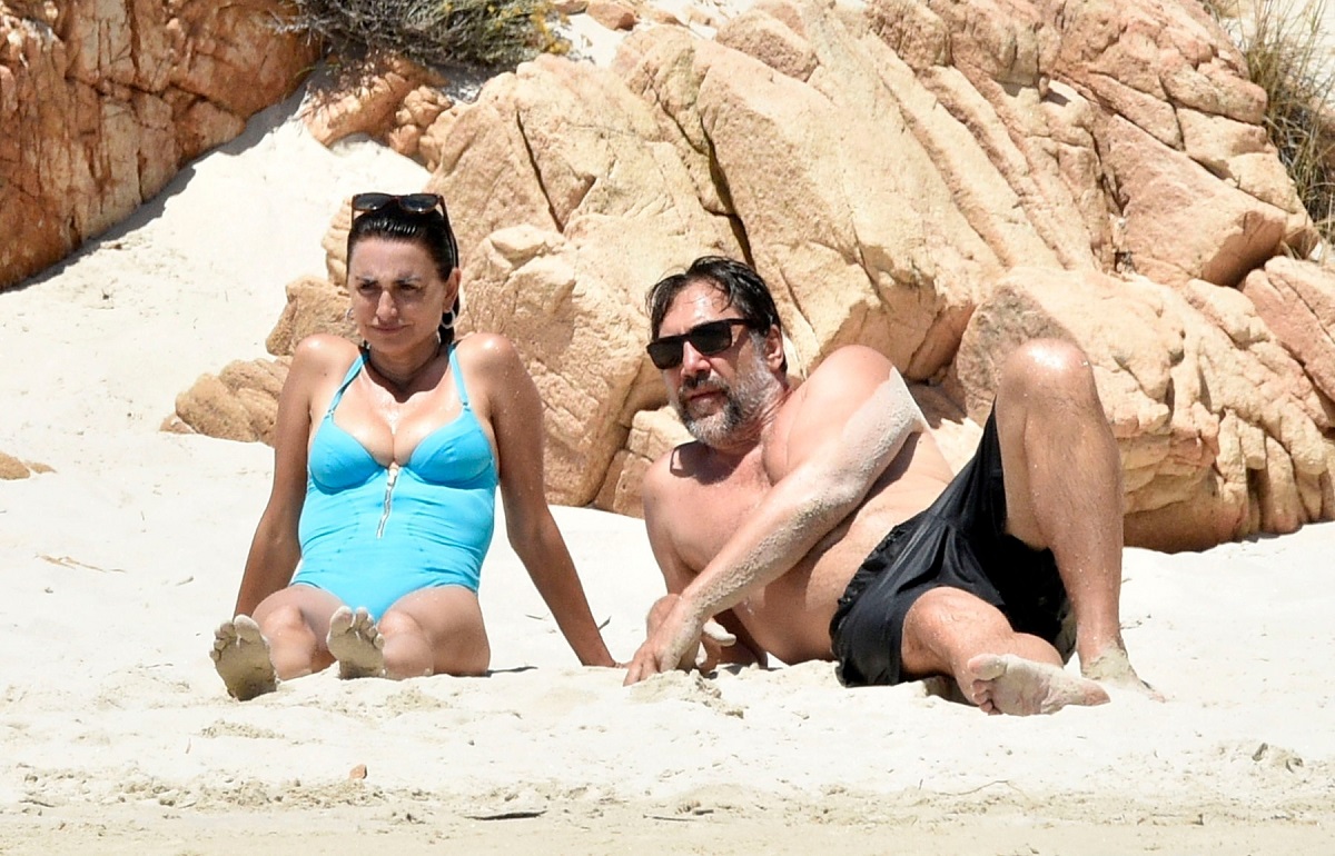 Penelope Cruz în timp ce stă întinsă pe nisip alături de soțul său Javier Bardem