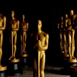 O încăpere neagră în care se află statui aurite în mărime naturală pentru decernarea premiilor după ce au fost anunțate predincțiile pentru Premiile Oscar 2022
