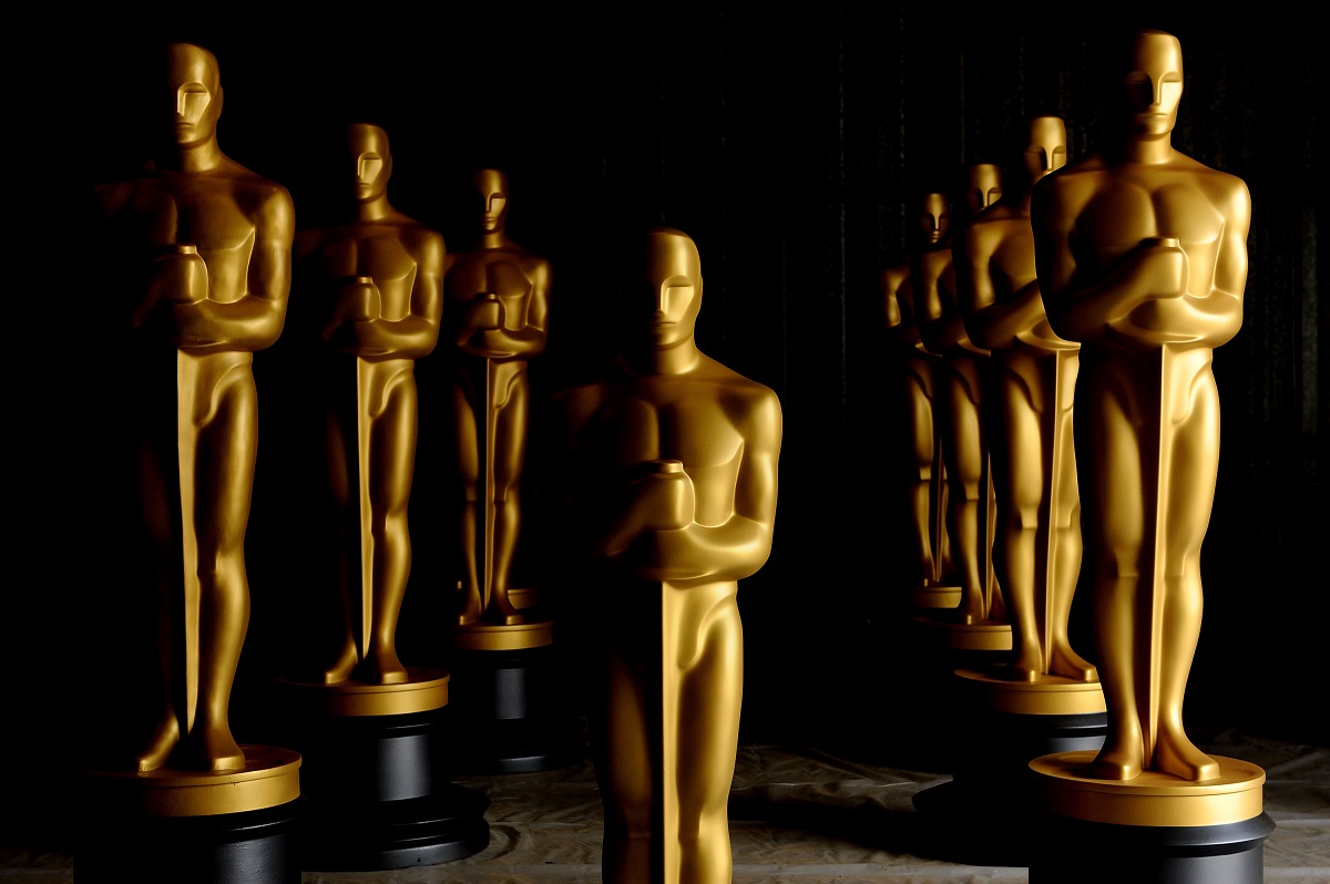O încăpere neagră în care se află statui aurite în mărime naturală pentru decernarea premiilor după ce au fost anunțate predincțiile pentru Premiile Oscar 2022