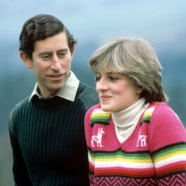 Prințul Charles într-o bluză de culoare smarald în timp ce o privește pe prințesa Diana care poartă o bluză roz cu dungi verzi și galbene, într-o imagine surprinsă după căsătoria lor