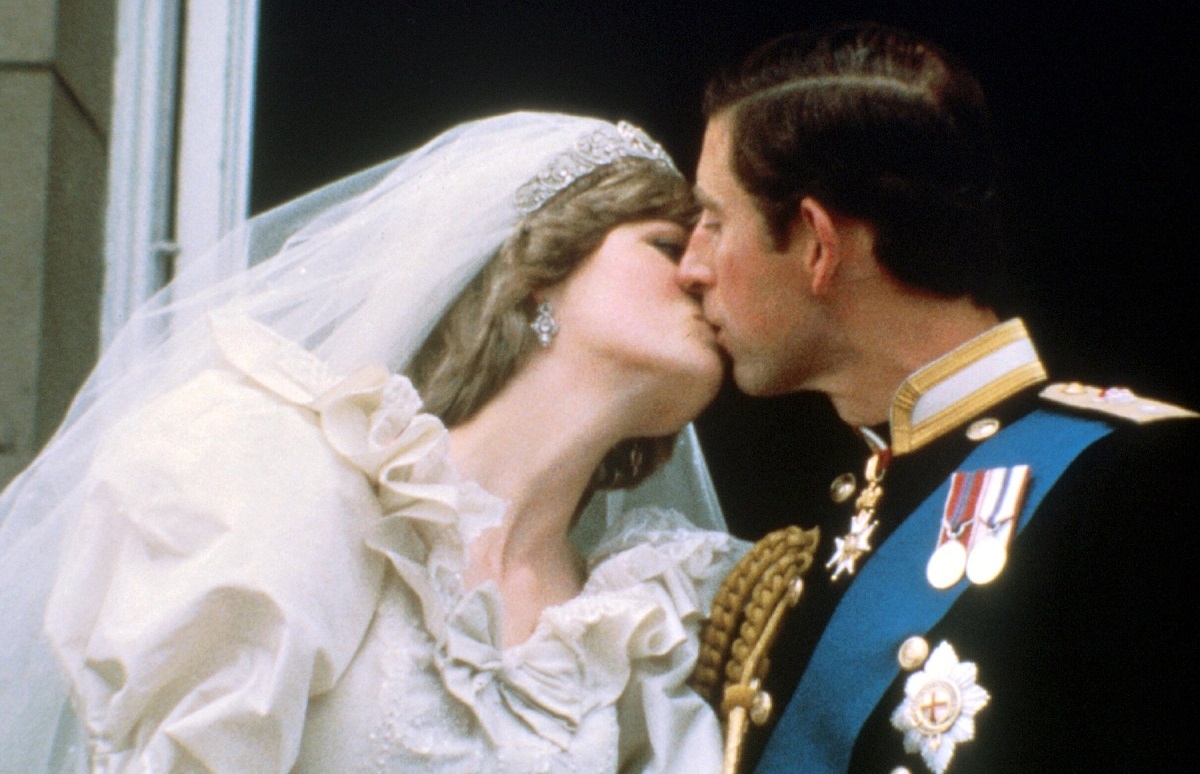 Prințesa Diana în rochie de mireasă în timp ce îl sărută pe Prințul Charles la balcon în 1981