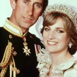 Portret cu Prințu Charles în uniformă militară care zâmbește, alături de soția sa, Prinșesa Diana care poartă rochie de mireasă la nunta lor din iulie 1981