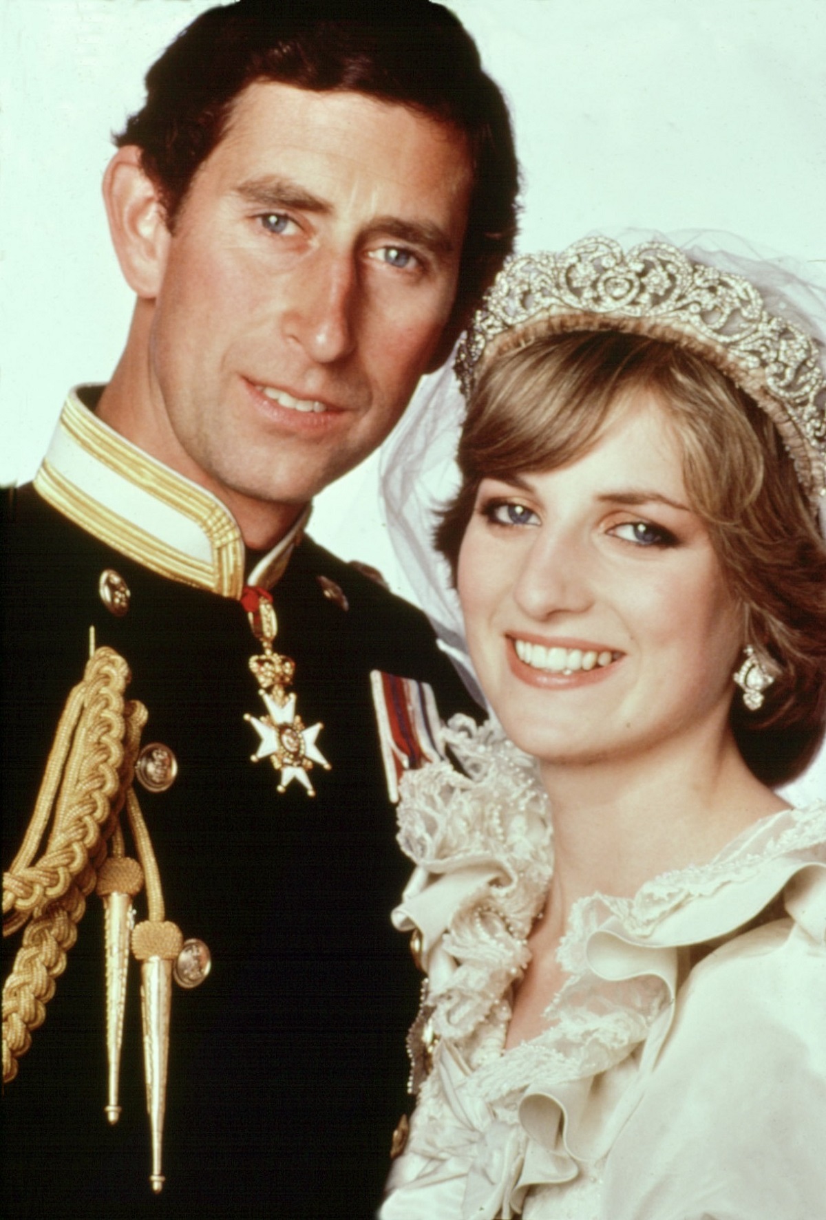Portret cu Prințu Charles în uniformă militară care zâmbește, alături de soția sa, Prinșesa Diana care poartă rochie de mireasă la nunta lor din iulie 1981