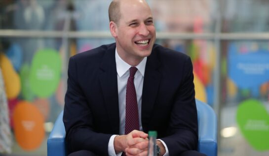 Prințul William pare mai fericit ca niciodată în timp ce stă în tribuna unui stadion și zâmbește