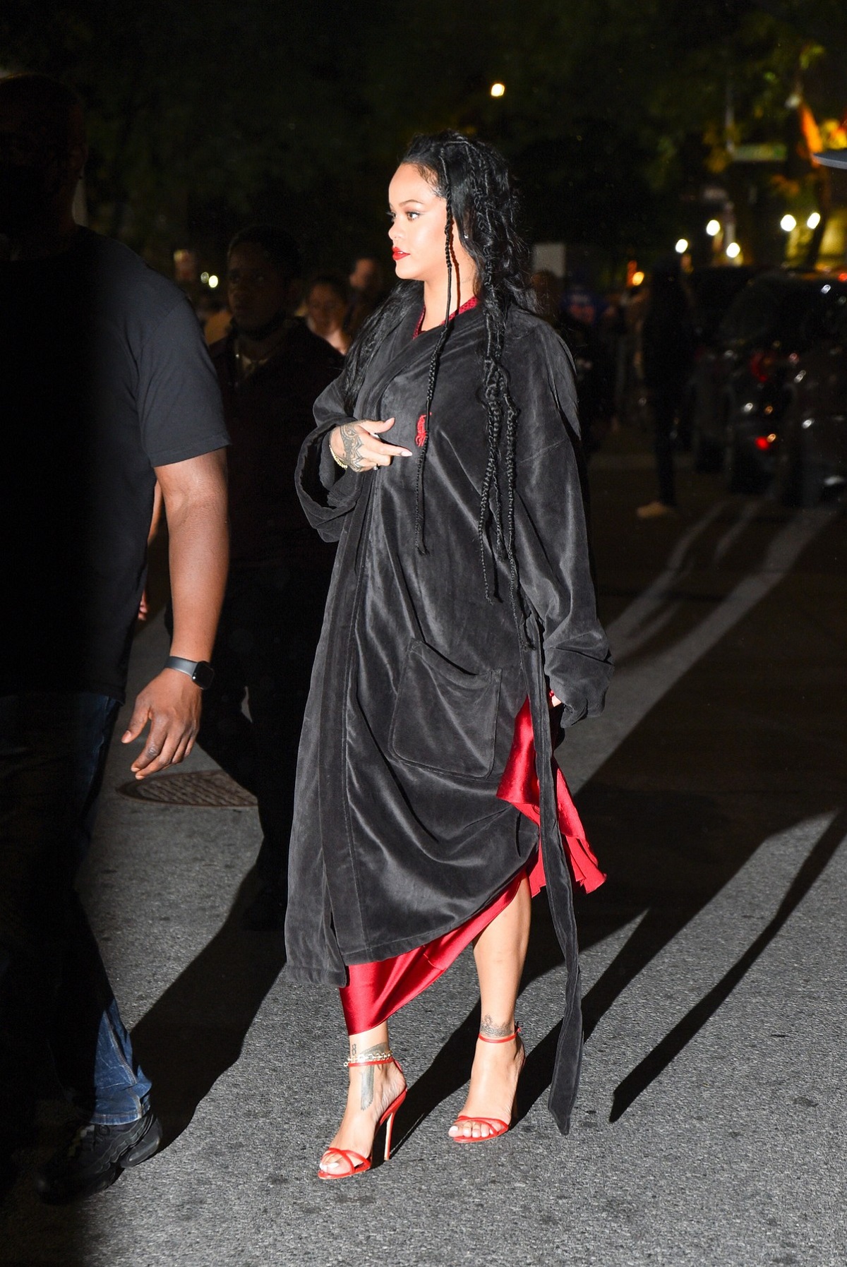 Rihanna într-un halat negru în timp ce încearcă să-și ascundă rochia roșie pe care a purtat-o la filmările celui mai nou videoclip muzical în colaborare cu A$AP Rocky