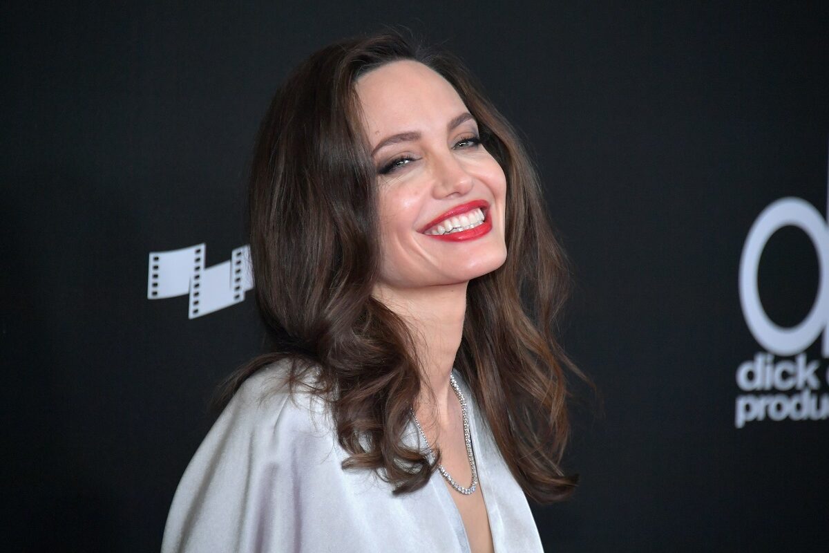 Angelina Jolie purtând o rochie albă și un ruj roșu în timp ce participă la o ceremonie de la Hollywood în anul 2017