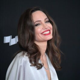 Angelina Jolie purtând o rochie albă și un ruj roșu în timp ce participă la o ceremonie de la Hollywood în anul 2017