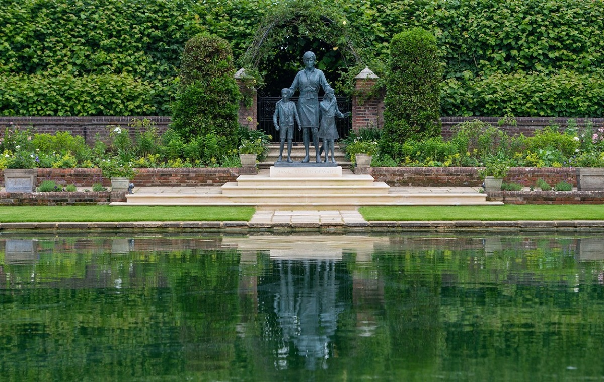 Imagine a statuii Prințesei Diana în fața unui lac în timp ce se află în grădinile din Palatul Kensington