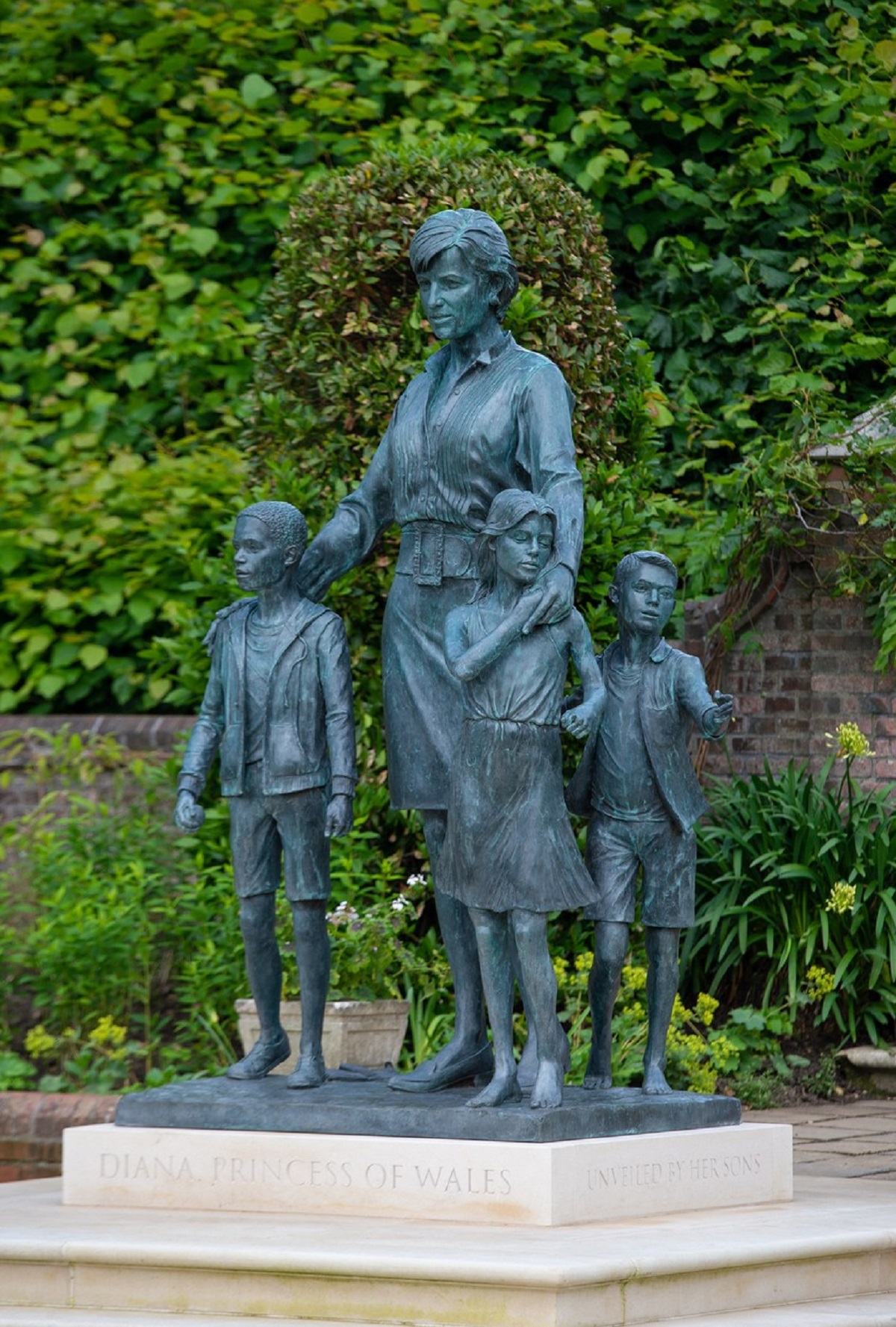 Fotografie a statuii Prințesei Diana langă care se află sculptați trei copii simbolizând implicarea sa și impactul pe care l-a avut de-a lungul generațiilor