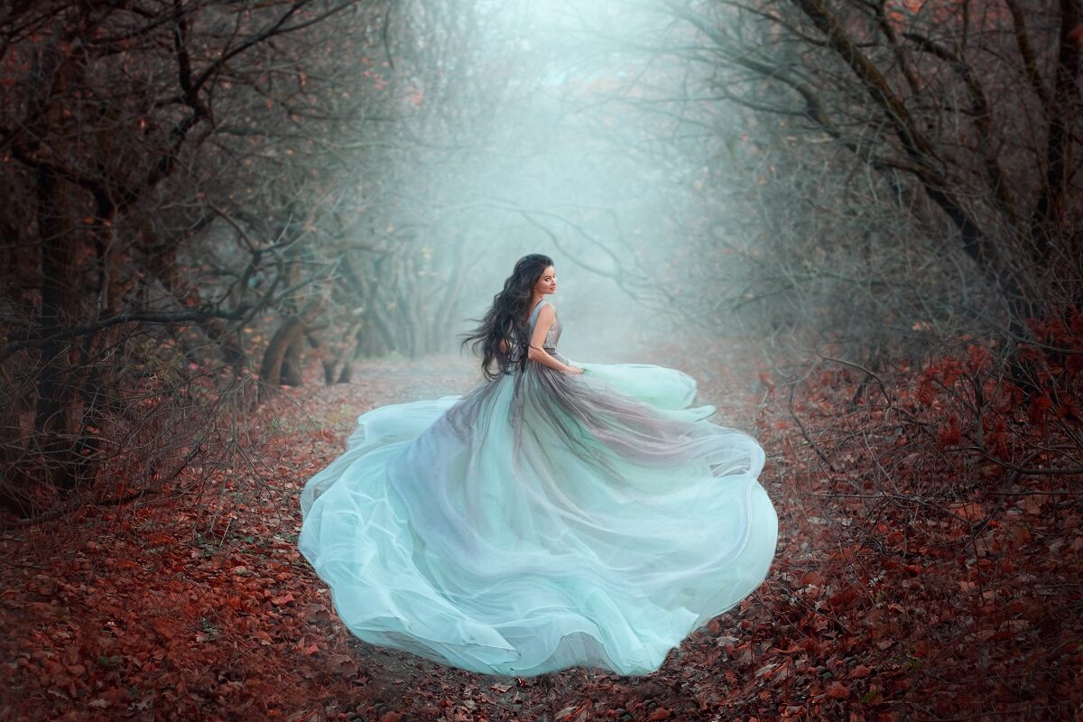 O femeie frumoasă într-o rochie superbă, vapăroasă de culoare alb în timp ce aleargă printr-o pădure în timpul toamnei pentru a reprezenta una din acele zodii care nu sunt făcute pentru căsătorie