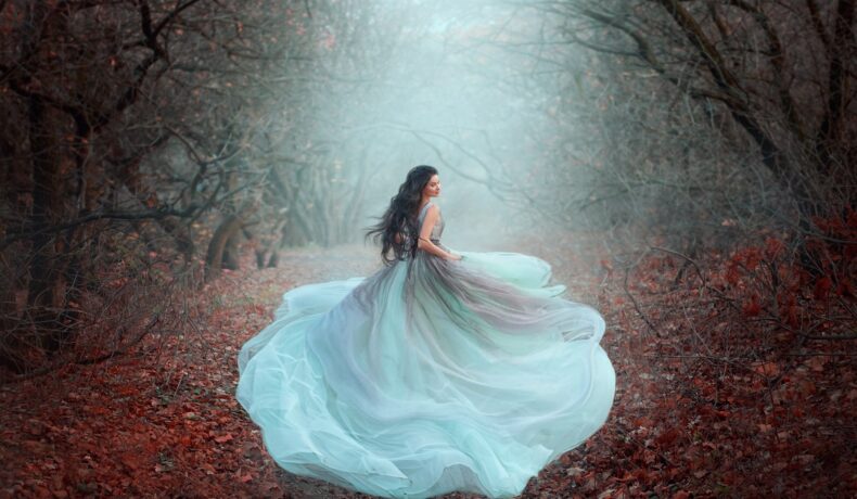 O femeie frumoasă într-o rochie superbă, vapăroasă de culoare alb în timp ce aleargă printr-o pădure în timpul toamnei pentru a reprezenta una din acele zodii care nu sunt făcute pentru căsătorie
