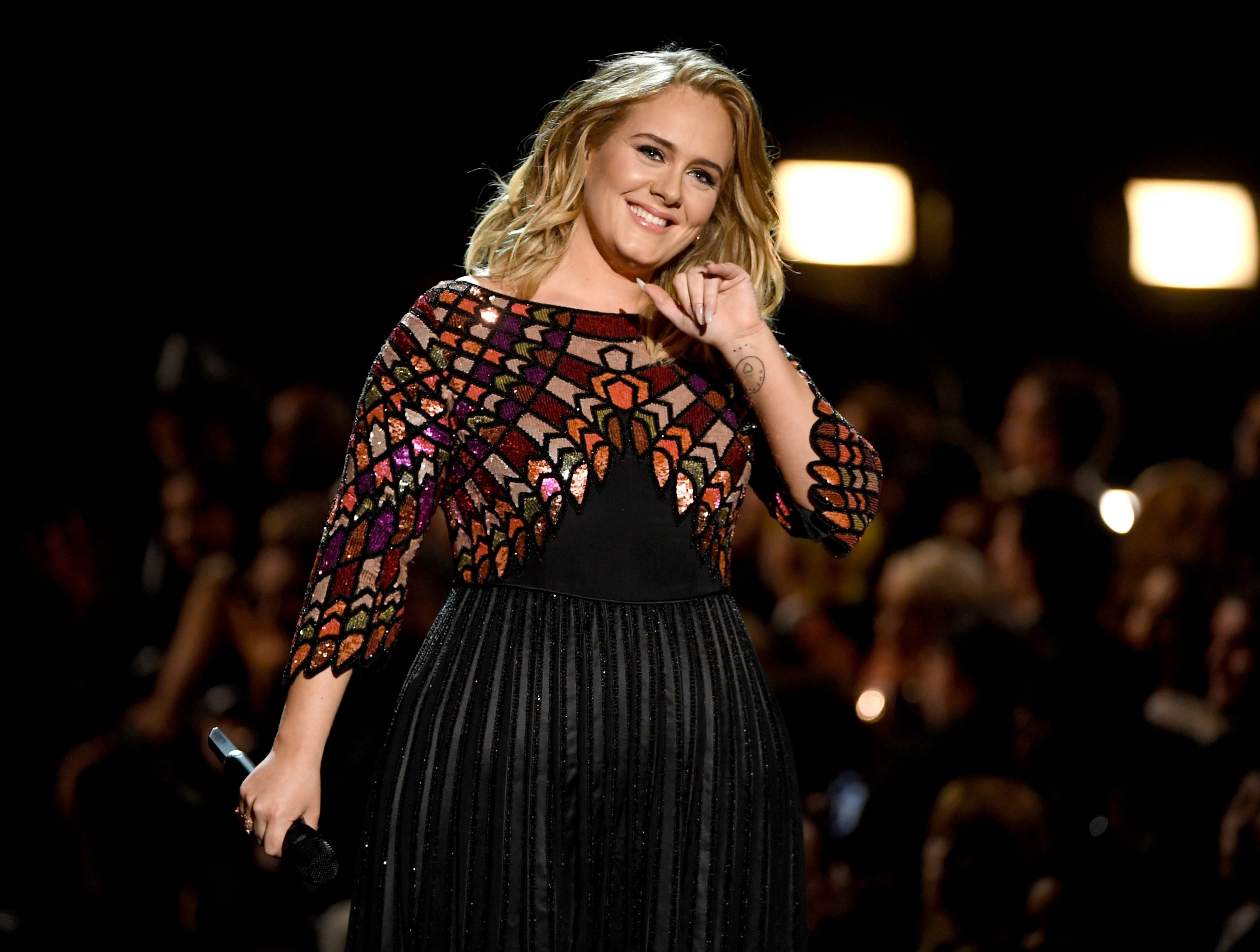 Adele, pe scena Premiilor Grammy la cea de-a 59-a ediție a evenimentului. Artista a îmbrăcat o rochie neagră, cu aplicații aurii și argintii pe umeri