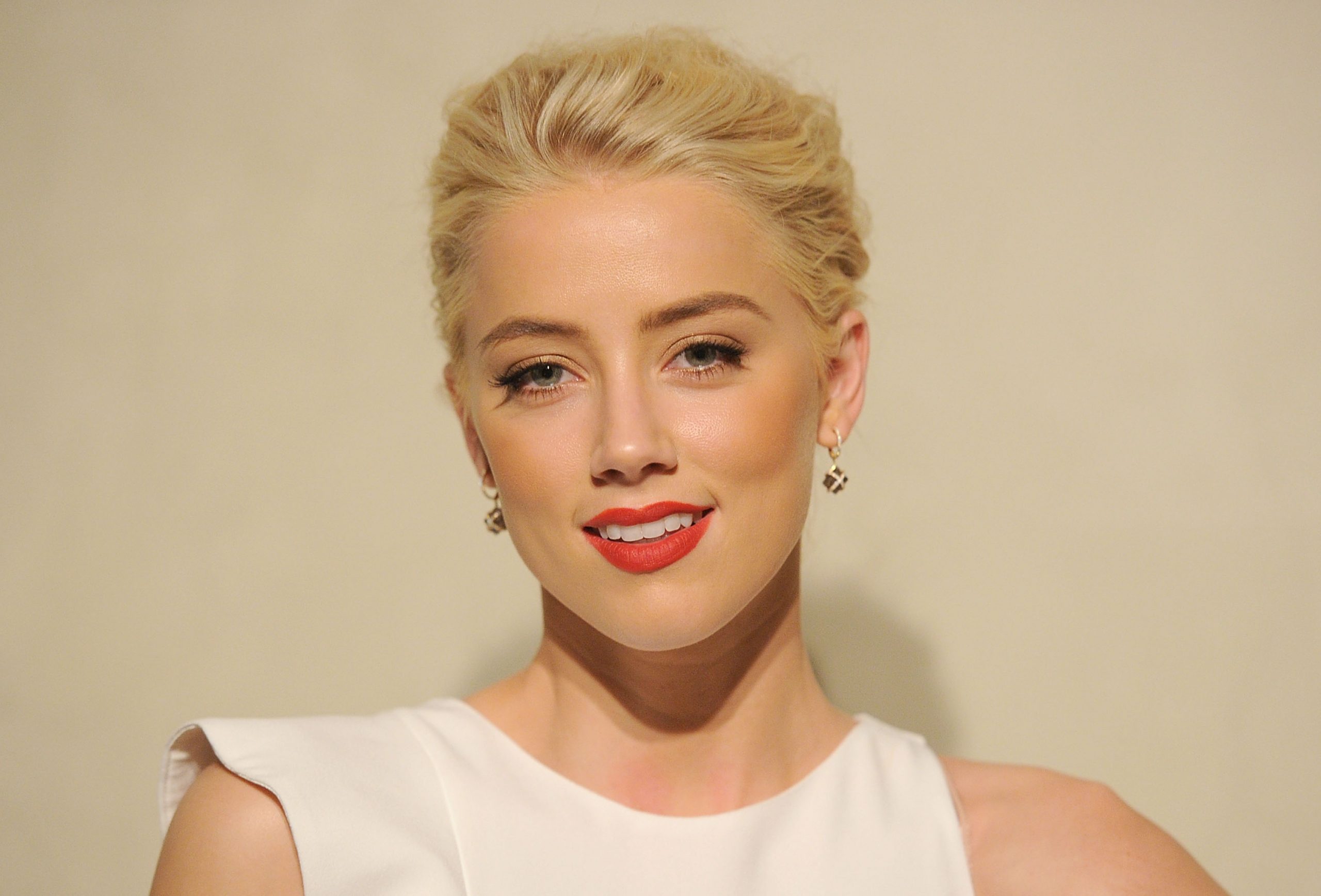 Amber Heard a participat la petrecerea Giorgio Armani/Vanity Fair în 2011 cu părul blond, rochie albă, ruj roșu