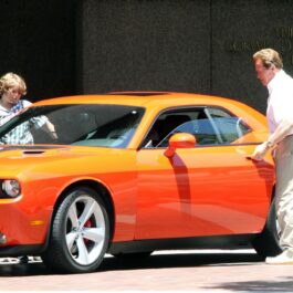 Christopher Schwarzenegger și Arnold, în timp ce se urcă într-o mașină portocalie, în anul 2009, în Brentwood