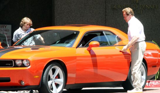 Christopher Schwarzenegger și Arnold, în timp ce se urcă într-o mașină portocalie, în anul 2009, în Brentwood