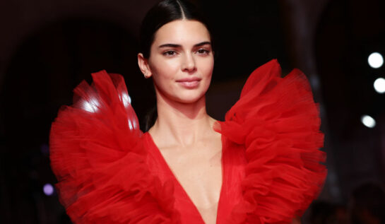 Kendall Jenner, îmbrăcată într-o rochie roșie, cu umeri bufanți, la prezentarea de modă Giambattista Valli Loves H&M
