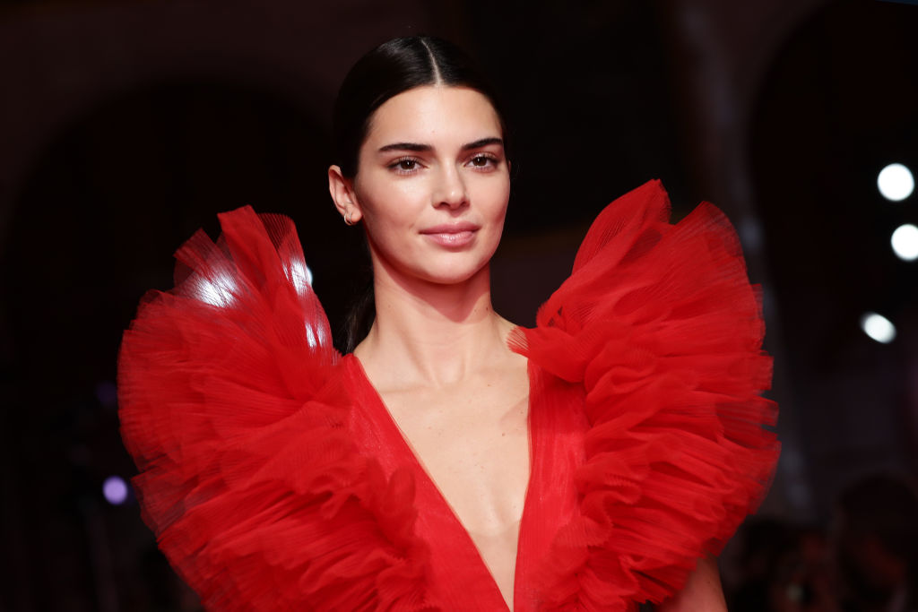 Kendall Jenner, îmbrăcată într-o rochie roșie, cu umeri bufanți, la prezentarea de modă Giambattista Valli Loves H&M