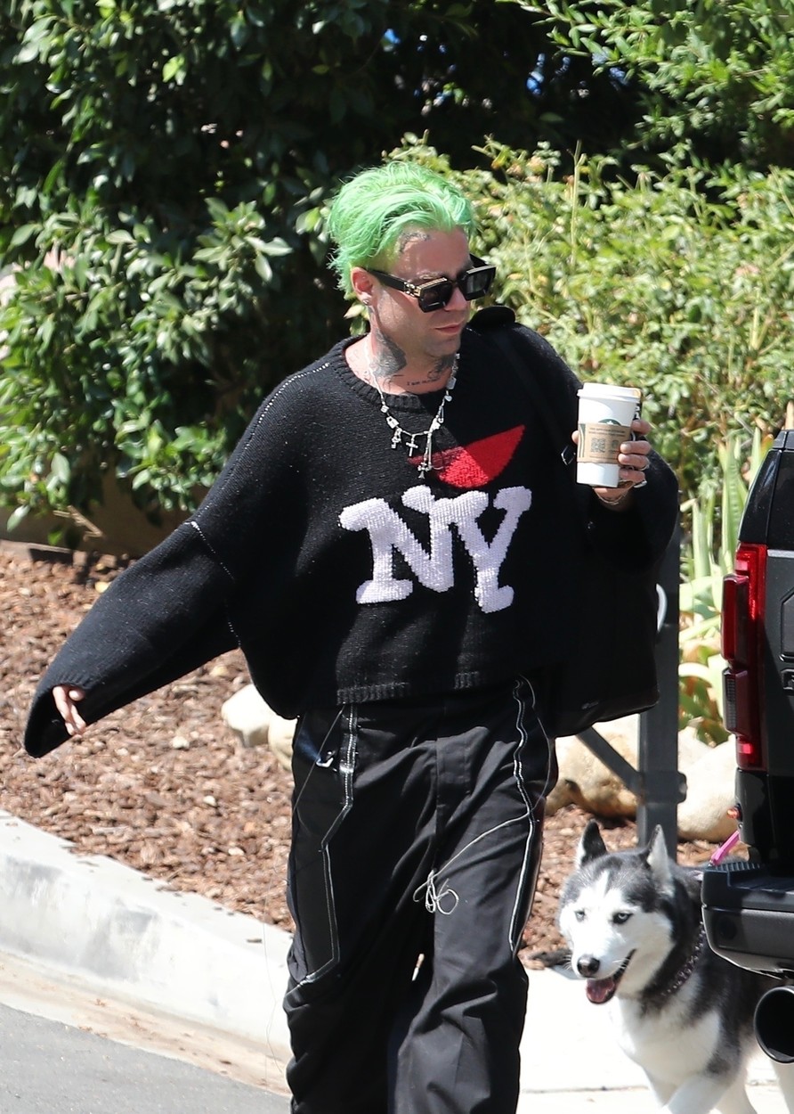 Mod Sun, îmbrăcat în negru, cu părul vopsit verde, cafea în mână, pe stradă în California