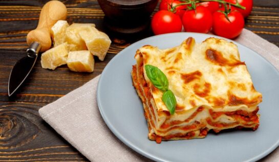 Porție de lasagna bolognese pe o farfurie gri