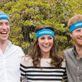 Prințul William, Prințul Harry, Kate Middleton în campania Heads Together, 2016. Toți trei au bentițe albastre pe cap, cu logo-ul campaniei. William poartă o bluză albă, Kate poartă o bluză cu dungi albe și negre și Harry poartă o cămașă neagră. Fundal cu verdeață