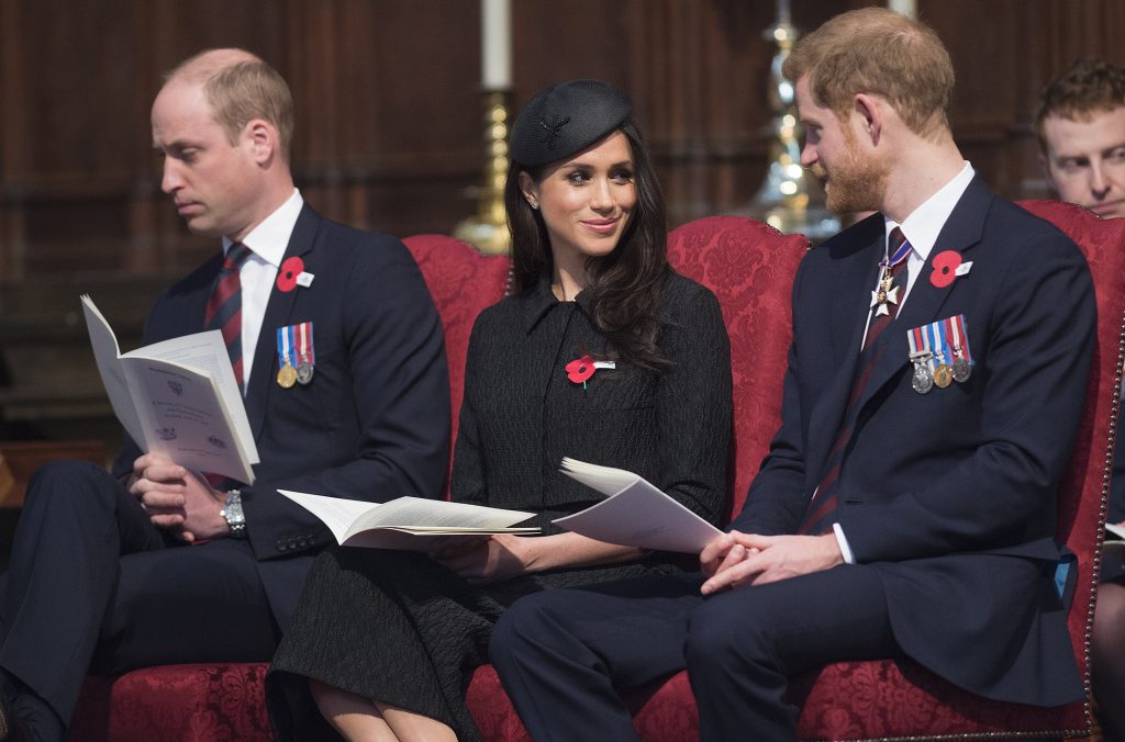 Prințul William, Prințul Harry, Meghan Markle, Anzac Day 2018, în Westminster Abbey. Toți trei s-au îmbrăcat în negru și stau pe scaune roșii