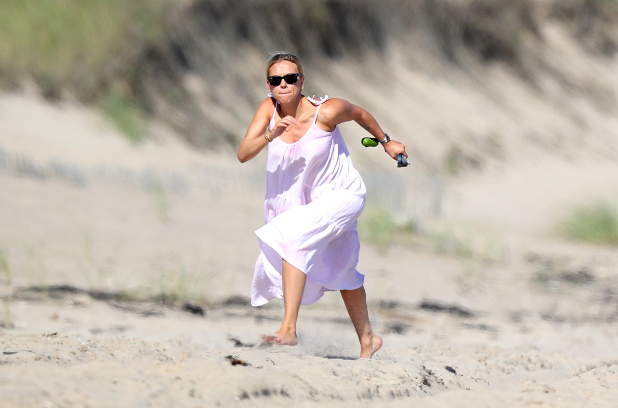 Scarlett Johansson pe plajă în The Hamptons, SUA. Actrița a optat pentru o rochie albă, largă, și o pereche de ochelari de culoare neagră