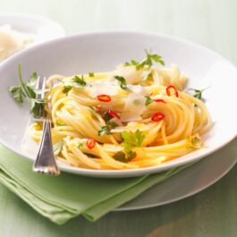 Spaghete aglio e olio într-o farfurie albă cu furculiță