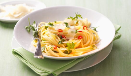 Spaghete aglio e olio într-o farfurie albă cu furculiță