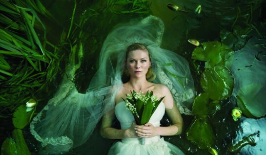 Kirsten Dunst în filmul Melancholia, 2011. E îmbrăcată ca o mireasă, cu un buchet de flori, într-un lac verde, cu nuferi