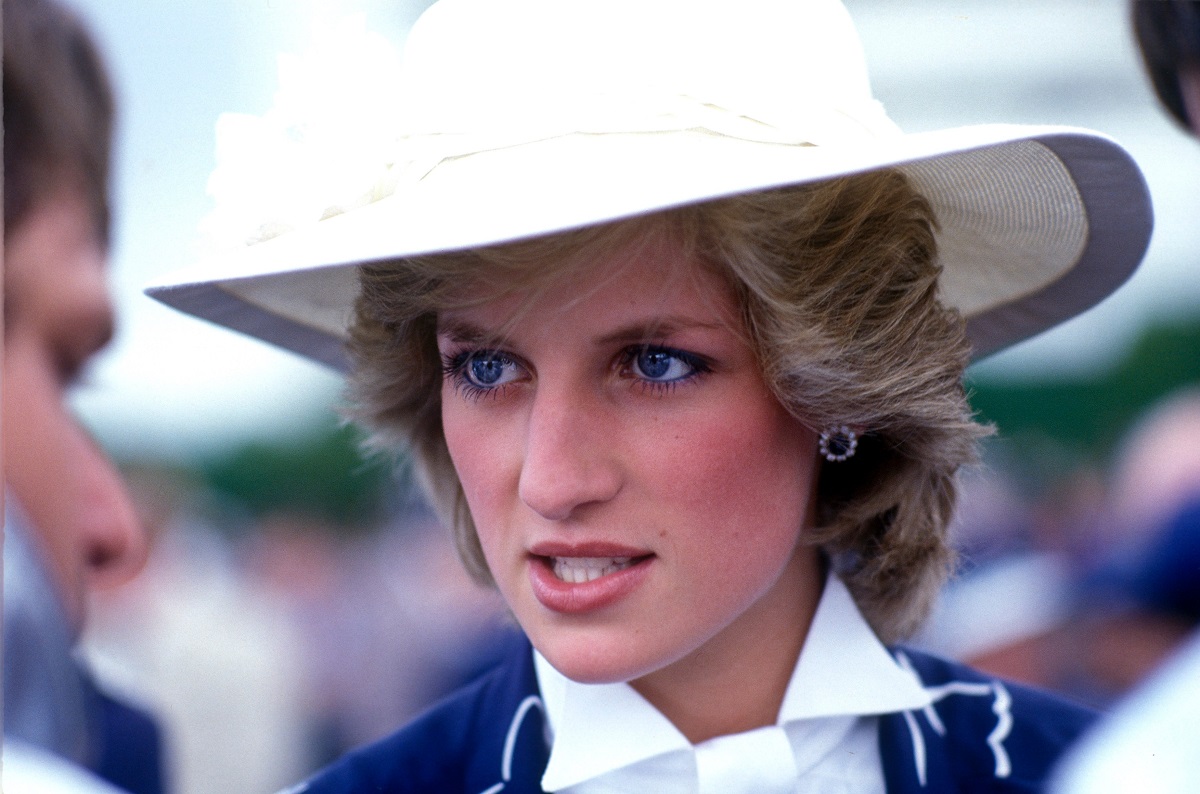 Prințesa Diana într-o vizită oficială în Noua Zeelandă. Are o pălărie albă, cu haină albastră și cămașă albă