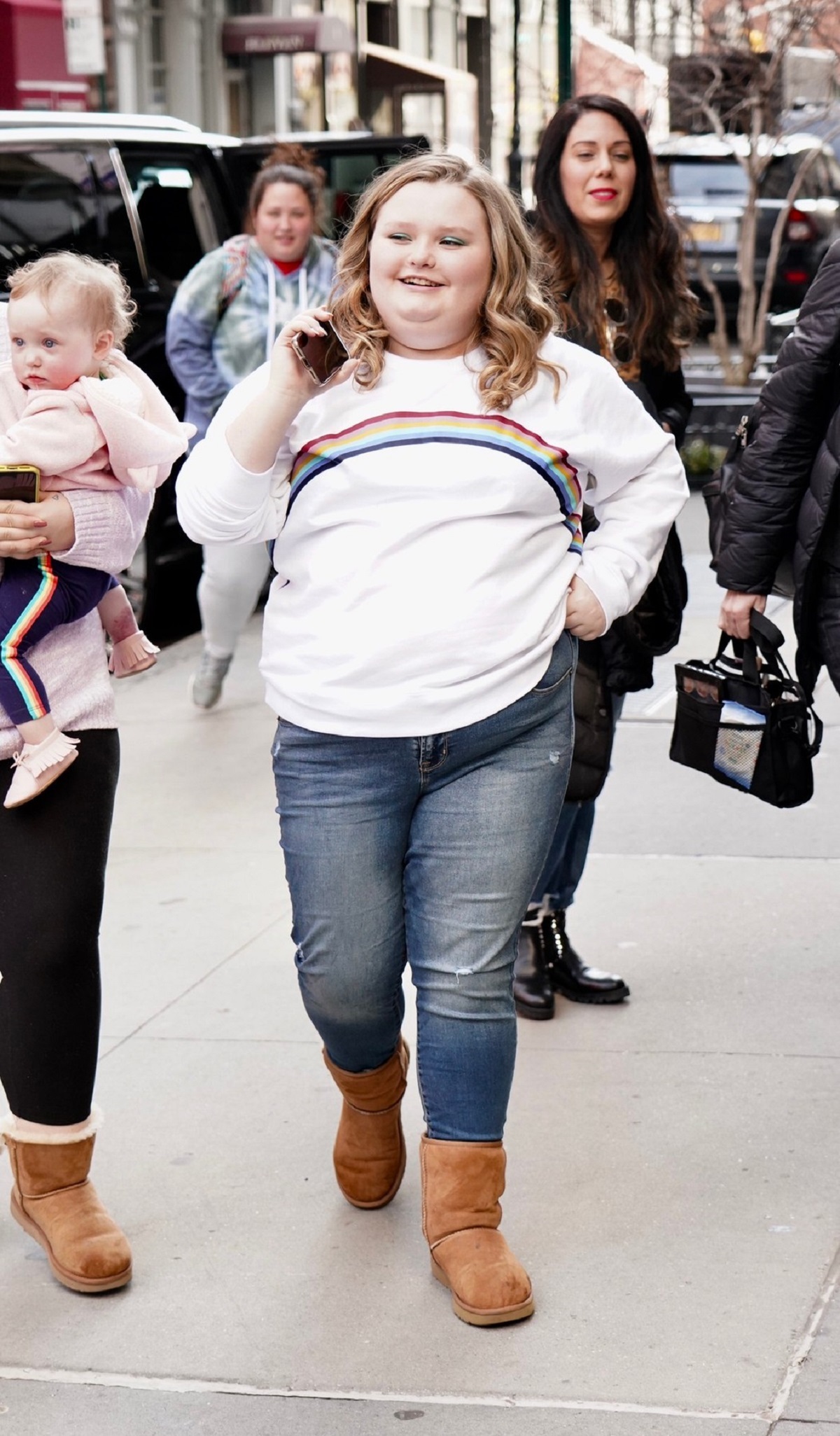 Alana Thompson într-o pereche de blugi și o bluză albă cu un curcubeu în timp ce se plimbă pe străzile din New York