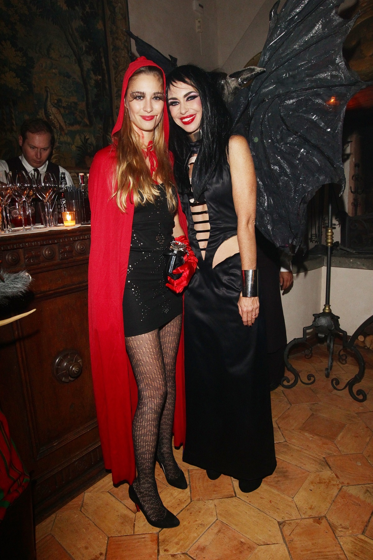 Beatrice Borromeo într-un costum de Halloween cu o rochie neagră și o capă roșie alături de prietena sa care poartă o rochie neagră la o petrecere privată de la Hollywood din anul 2012