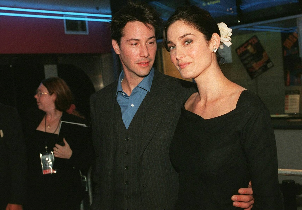 Keanu Reeves alături de Carrie Anne Moss în timp ce se țin îmbrățișați la premiera din Australia a filmului The Matrix din 1999