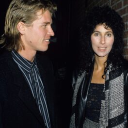 Cher care poartă o bluză neagră din dantelă și o fustă gri, alături de iubitul său Val Kilmer în anul 1984