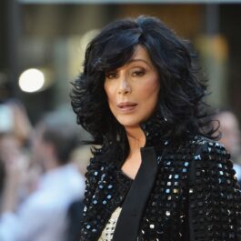 Cântăreața Cher cu părul scurt și ondulat în timp ce poartă o jachetă neagră cu pietre în anul 2013