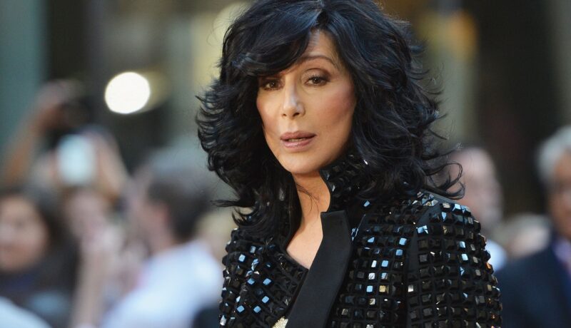 Cântăreața Cher cu părul scurt și ondulat în timp ce poartă o jachetă neagră cu pietre în anul 2013