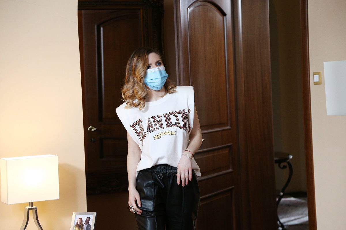 Cristina Ciobănașu într-un tricou alb cu imprimeu, purtând mască pe platourile de filmare de la serialul Adela