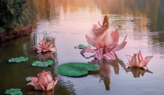 O zână frumoasă într-o rochie roz care dansează pe o floare de nufăr în timp ce seaflă pe un lac umplut cu nuferi și se gândește la acele gesturi pe care zodiile de apă le adoră într-o relație