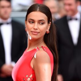 Portret al fotomodelului Irina Shayk în timp ce privește peste umăr într-o rochie roșie la festivalul de film de la Cannes din 2018