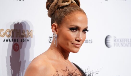 Jennifer Lopez cu părul prins într-un coc în timp ce pozează pe covorul roșu în 2018