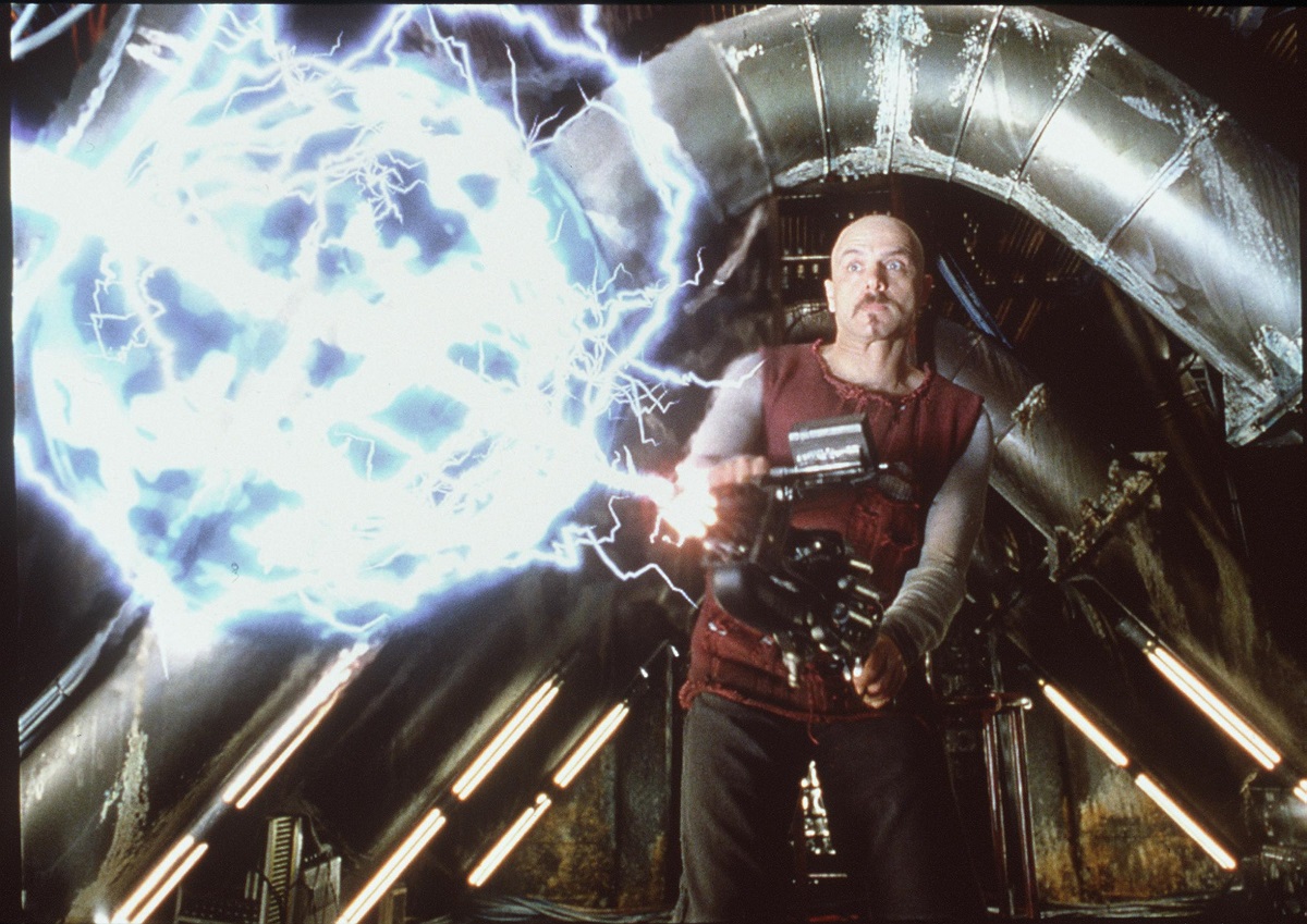 Actorul Joe Pantolino ținând în mână un furtun electric într-o scenă din filmul Matrix din 1999