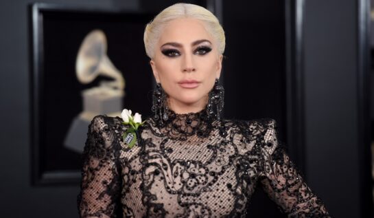 Lady Gaga într-o rochie neagră cu o floare albă în piept la Gala GRAMMY din 2018