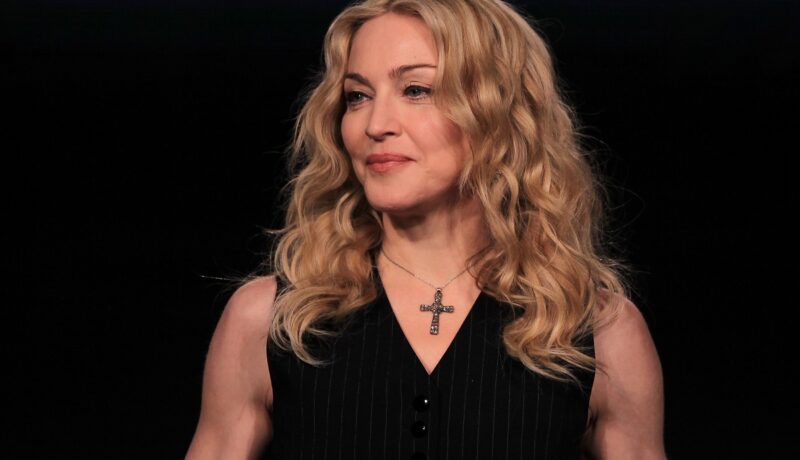 Madonna într-o bluză neagră cu o cruciuliță la gât în timp ce particiă la Super Bowl în 2012