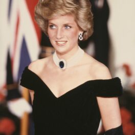 Prințesa Diana într-o rochie neagră pe umeri în timp ce zâmbește după ce a participat la un eveniment de la Casa Albă în 1985