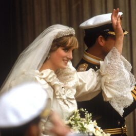 Prințesa Diana în rochie de mireasă alături de Prințul Charles în uniformă, în timp ce fac cu mâna publicului la nunta regala din 1981