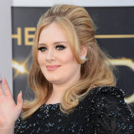 Adele, fotografiată în timp ce face cu mâna, pe covorul roșu, la Annual Academy Awards, în 2013